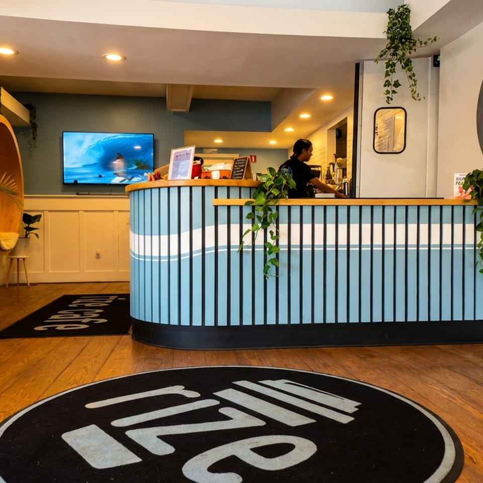 Modern cafe interior with a blue and white striped counter, a person, and Rize branding.